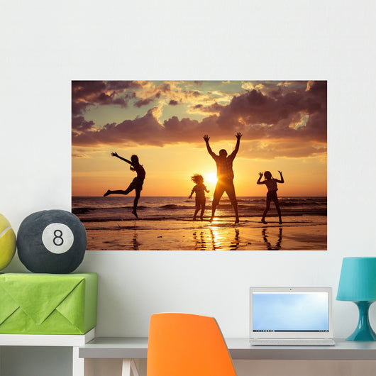 Father and children playing on the beach Wall Mural
