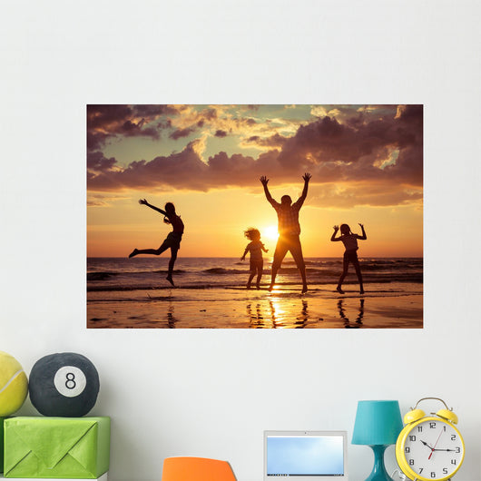 Father and children playing on the beach Wall Mural