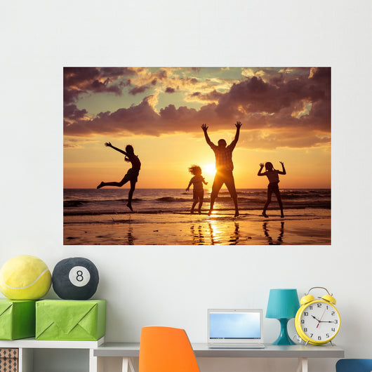 Father and children playing on the beach Wall Mural