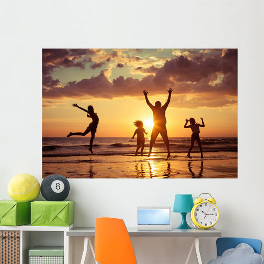 Father and children playing on the beach Wall Mural