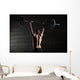 Portrait of a handsome athlete from behind. Athlete raises the b Wall Mural
