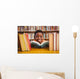 Cute boy reading book in library Wall Mural