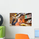Cute boy reading book in library Wall Mural