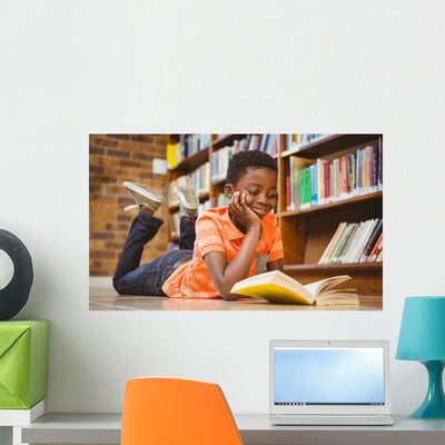 Cute Boy Reading Book In Library Wall Decal shown on a wall