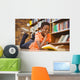 Cute boy reading book in library Wall Mural