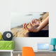 The woman meditating in a yoga pose on the tropical beach. Wall Mural