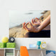 The woman meditating in a yoga pose on the tropical beach. Wall Mural