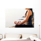 The woman meditating in a yoga pose on the tropical beach. Wall Mural