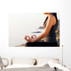 The woman meditating in a yoga pose on the tropical beach. Wall Mural