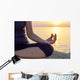 The woman meditating in a yoga pose on the tropical beach. Wall Mural
