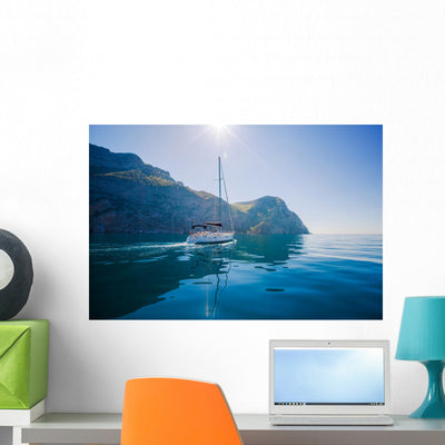 Yacht Sailing along Shore Wall Mural shown on a wall