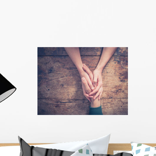 Man and woman holding hands at a table Wall Mural