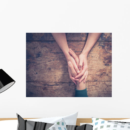 Man and woman holding hands at a table Wall Mural