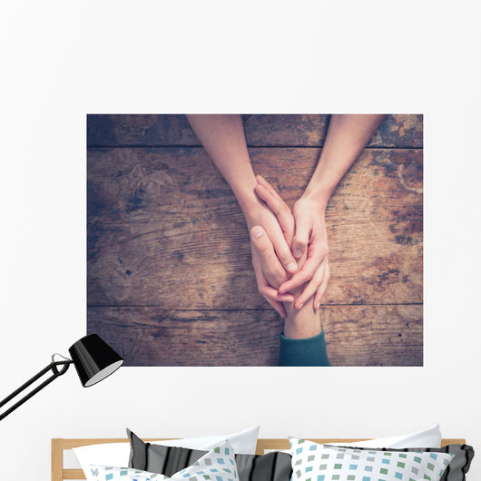Man and woman holding hands at a table Wall Mural