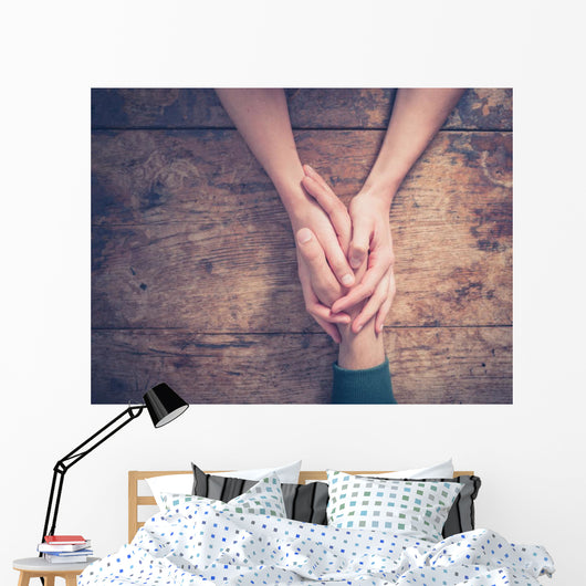 Man and woman holding hands at a table Wall Mural