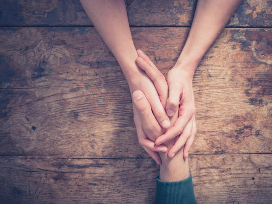 Man and woman holding hands at a table Wall Mural