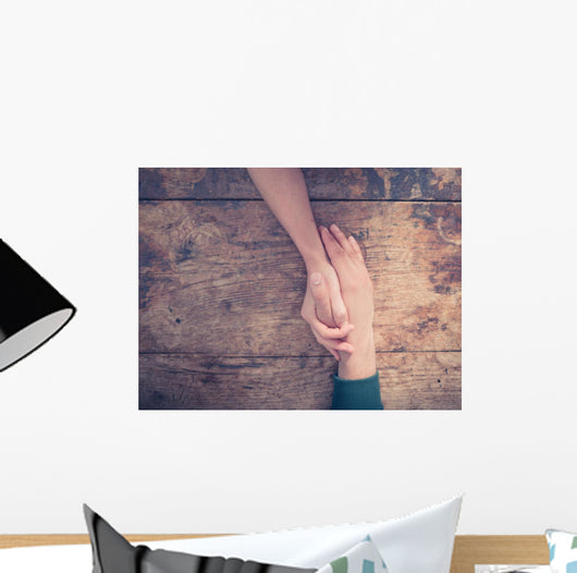 Man and woman holding hands at a table Wall Mural