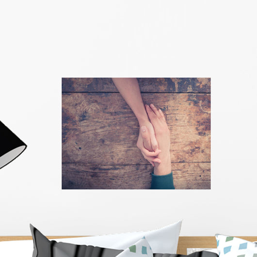 Man and woman holding hands at a table Wall Mural