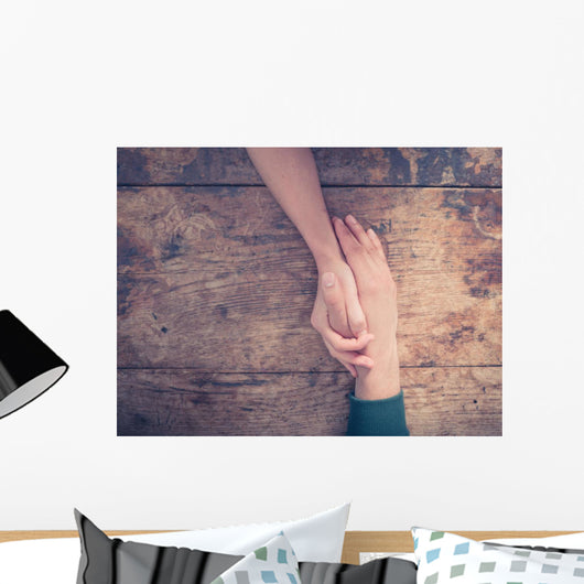 Man and woman holding hands at a table Wall Mural
