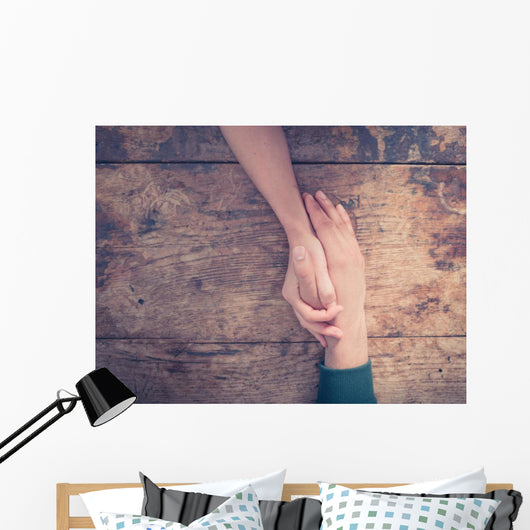 Man and woman holding hands at a table Wall Mural