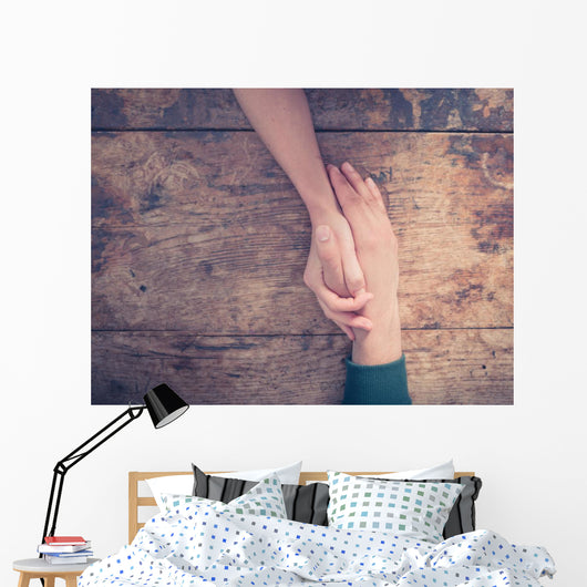 Man and woman holding hands at a table Wall Mural