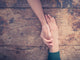 Man and woman holding hands at a table Wall Mural