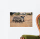 Lone rhino standing on open area looking for safety from poacher Wall Mural
