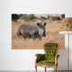 Lone rhino standing on open area looking for safety from poacher Wall Mural