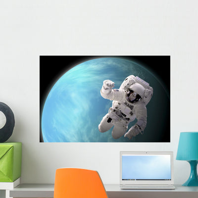 Artist's Concept Astronaut Floating Blue Planet Wall Decal shown on a wall