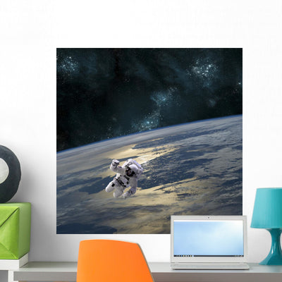 Astronaut Floating above Earth Wall Decal shown on a wall