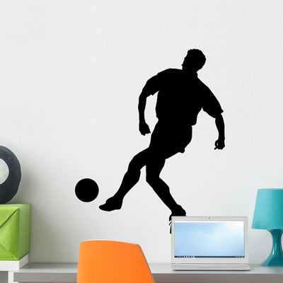 Kicking Soccer Silhouette Wall Decal shown on a wall