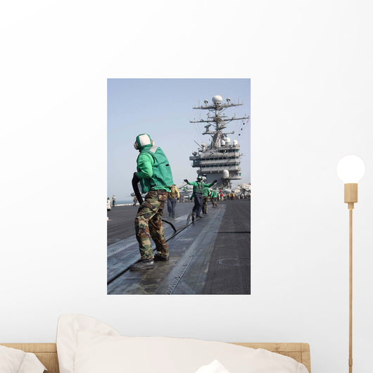 Air Department Crewmembers Remove Wall Decal