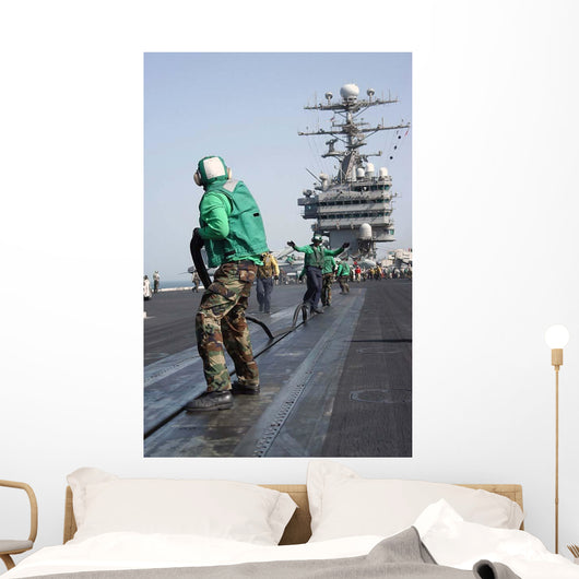 Air Department Crewmembers Remove Wall Decal