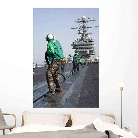Air Department Crewmembers Remove Wall Decal