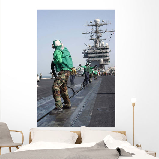 Air Department Crewmembers Remove Wall Decal